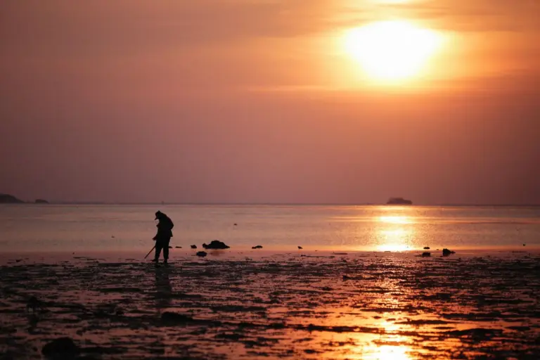 Einzelne Person als Silhouette am Strand bei Sonnenuntergang