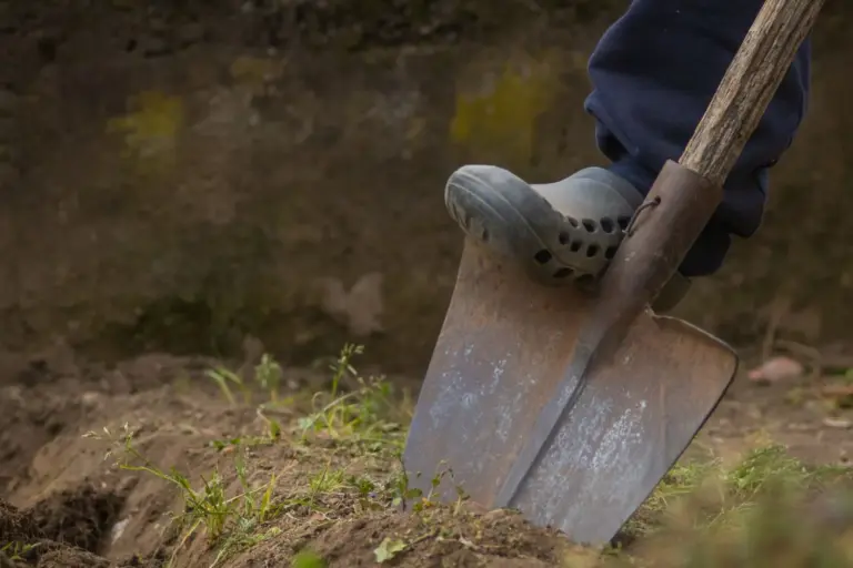 Fuß auf einem Spaten bei der Gartenarbeit