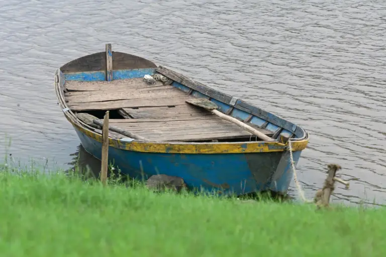 Holzboot am Ufer eines ruhigen Gewässers