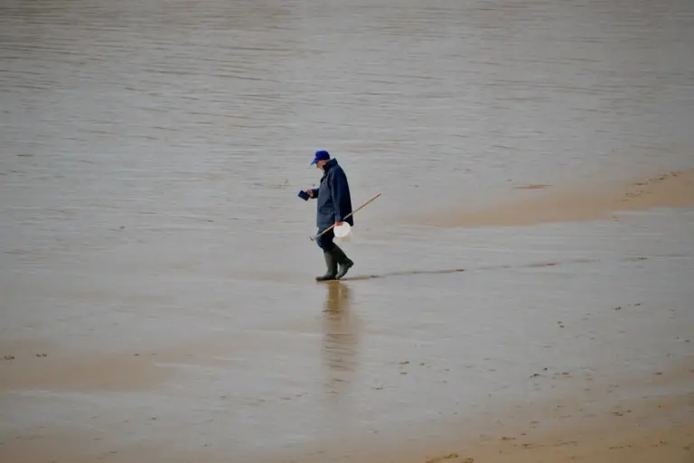 Person geht bei Ebbe über nassen Sand