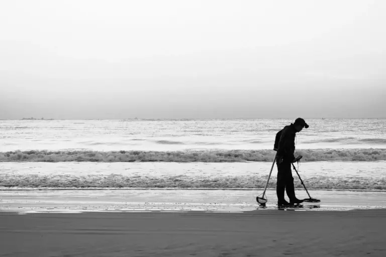 Silhouette eines Mannes mit Metalldetektor an einem ruhigen Strand